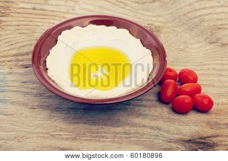 Lebanese food of Labneh Yogurt cheese and cherry tomato on wooden background with retro filter effec