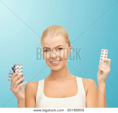 health, medicine, diet and pharmacy concept - young woman with variety of pills