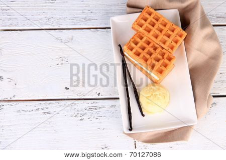 Tasty belgian waffles with ice cream on wooden table