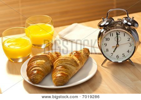 gesunde Kontinentalfrühstück Croissant, Orangensaft & Wecker