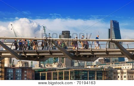 LONDON, UK - AUGUST 9, 2014: Millennium bridge next to St. Paul cathedral and Tate gallery with peop