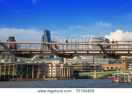 LONDON, UK - AUGUST 9, 2014: Millennium bridge next to St. Paul cathedral and Tate gallery with peop