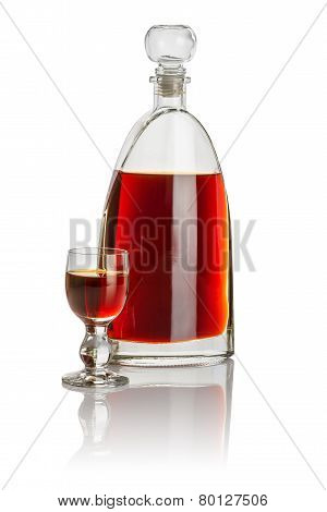Carafe and glass goblet filled with brown liquid