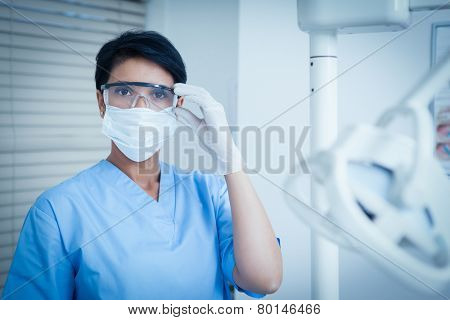 Portrait of female dentist wearing surgical mask and safety glasses