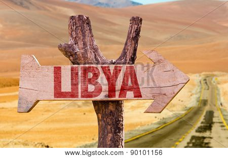 Libya wooden sign with desert road background