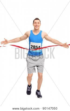 Full length portrait of a male runner with a race number on his chest, crossing the finish line isolated on white background