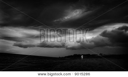 Immagine in bianco e nero scuro di una tempesta, mare, nuvole e persone Silhouette