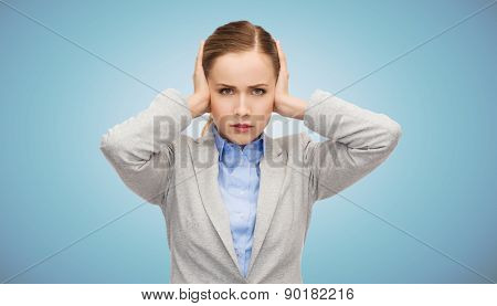 business, emotions, stress, pressure and people concept - stressed businesswoman with covered ears over blue background