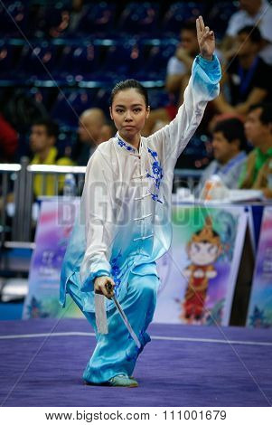JAKARTA, INDONESIA - NOVEMBER 15, 2015: Lindswell Kwok of Indonesia performs the movements in the women's Taijijian event at the 13th World Wushu Championship 2015 held at Istora Senayan, Jakarta.