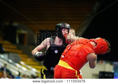 JAKARTA, INDONESIA - NOVEMBER 15, 2015: Alessandro Cutuli of Italy (red) fights Aleksandr Yudin of Ukraine (black) in the men's 70kg Sanda event at the 13th World Wushu Championship 2015.