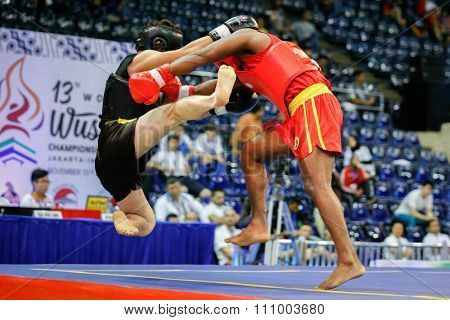 JAKARTA, INDONESIA - NOVEMBER 15, 2015: Ishan Naligamage of Sri Lanka (red) fights Saipiev Ilgizbek of Kazakhstan (black) in the men's 70kg Sanda event at the 13th World Wushu Championship 2015.