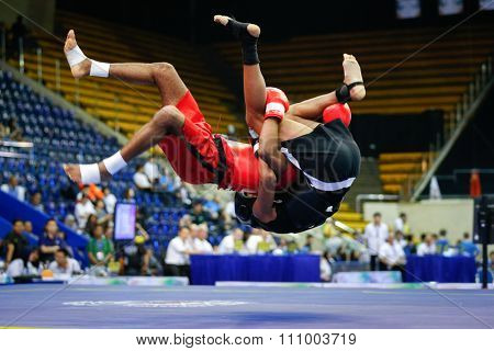 JAKARTA, INDONESIA - NOVEMBER 15, 2015: Saad Boujekka of Morocco (red) fights Peter Michaels of South Africa (black) in the men's 70kg Sanda event at the 13th World Wushu Championship 2015.