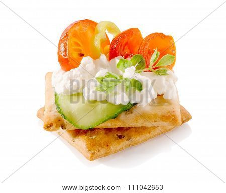 appetizer on crackers with cream cheese and vegetables close-up isolated