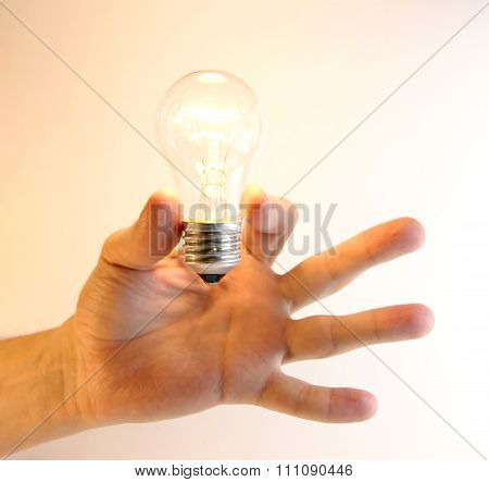Lighting lamp flashing bulb in human hand on white background