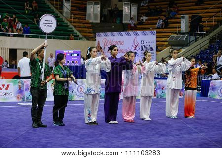 JAKARTA, INDONESIA - NOVEMBER 16, 2015: Athletes take to the arena to commence the Women's Compulsory Taijiquan event at the 13th World Wushu Championship 2015 at the Istora Senayan Stadium.