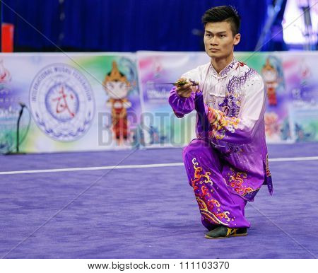 JAKARTA, INDONESIA - NOVEMBER 16, 2015: Jack Chang Loh of Malaysia performs the movements in the Men's Taijijian event at the 13th World Wushu Championship 2015 at the Istora Senayan Stadium.