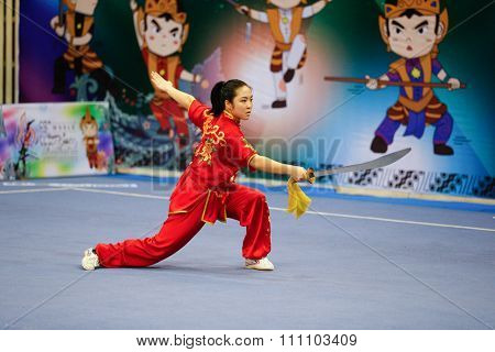 JAKARTA, INDONESIA - NOVEMBER 16, 2015: Ami Li of the USA performs the movements in the women's Daoshu event at the 13th World Wushu Championship 2015 at the Istora Senayan Stadium.