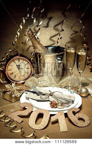 New year holiday table setting with champagne. Celebration. Place setting for new year eve. Holiday decorations. Served table