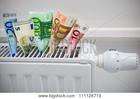 heating thermostat with money, expensive heating costs concept
