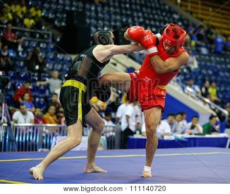 JAKARTA, INDONESIA - NOVEMBER 16, 2015: Praveen Biswakarma of Hong Kong (red) fights Oleksandr Yudin of Ukraine (black) in the men's 70kg Sanda event at the 13th World Wushu Championship 2015.