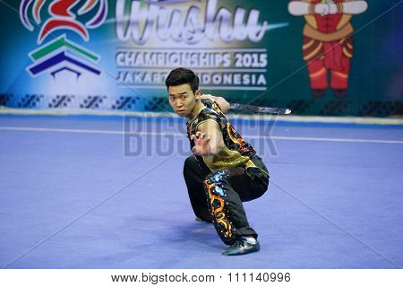 JAKARTA, INDONESIA - NOVEMBER 16, 2015: Yongmun Lee of South Korea performs the movements in the men's Nandao event at the 13th World Wushu Championship 2015 at the Istora Senayan Stadium.