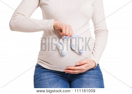 hands of happy pregnent woman holding child socks