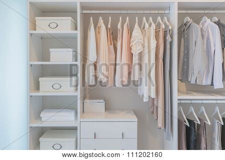 Clothes Hanging On Rail In White Wardrobe