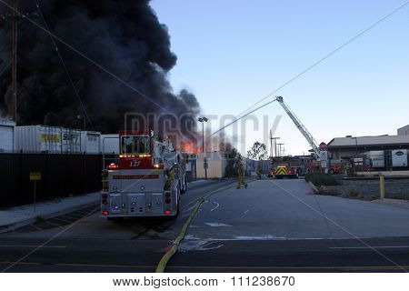 HARBOR GATEWAY, CALIFORNIA- DECEMBER 12, 2015: Fire erupts at recycling yard in Harbor Gateway. Fire Fighters battle Hot Flames and Thick Black smoke trying to put out a fire, California Dec. 12, 2015