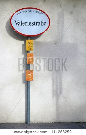 A nostalgic road sign of Archduke Valerie Street in Austria casts a shadow on the wall.