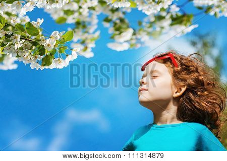 Little Girl Closed Her Eyes And Breathes The Fresh Air In The Park.