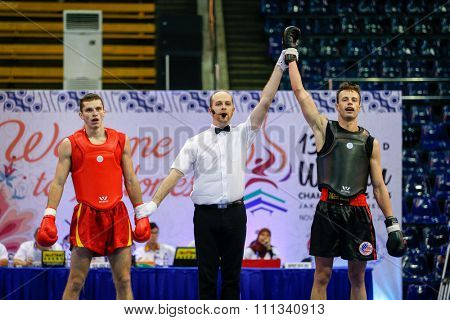 JAKARTA, INDONESIA - NOVEMBER 17, 2015: Andrei Nedikov of Belarus (red) loses to Gary Chandler of the USA (black) in the men's 65kg Sanda event at the 13th World Wushu Championship 2015.