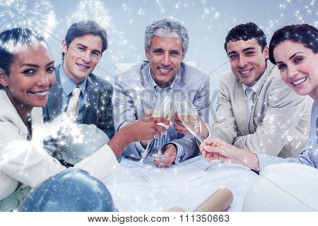 Smiling architectutal team celebrating a success with champagne against white fireworks exploding on black background