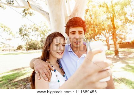 Young couple in the park making their selfi with mobile phone