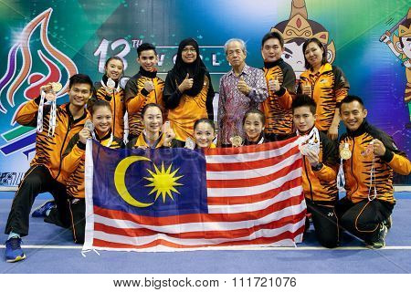 JAKARTA, INDONESIA - NOVEMBER 17, 2015: The Malaysian Wushu taolu athletes show off the medals they won at the 13th World Wushu Championship 2015 held at the Istora Senayan Stadium.