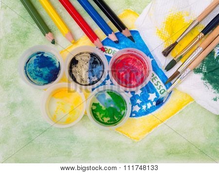 Paints Lids,brushes, Pencils And Stained Fabric On The Brazil Flag Watercolor Painting