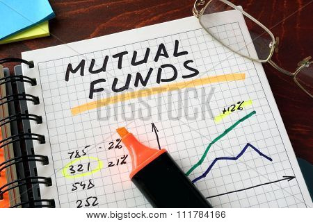 Notebook with mutual funds  sign on a table.