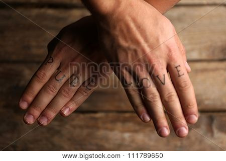 Tattoo inscriptions on male fingers drawn with marker