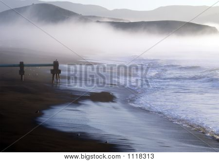 La nebbia bassa in rotoli sull'oceano.