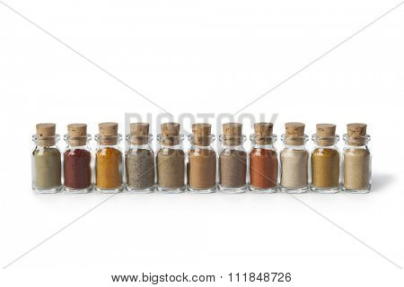 Row of glass bottles with different powder herbs on white background