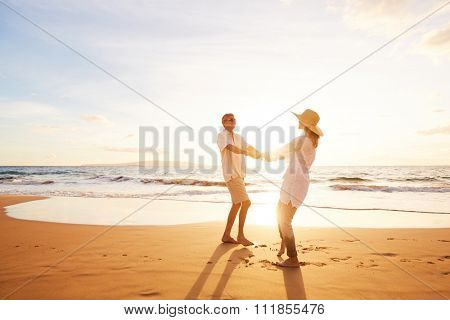 Happy Romantic Middle Aged Couple Enjoying Beautiful Sunset on the Beach. Travel Vacation Retirement Lifestyle Concept.