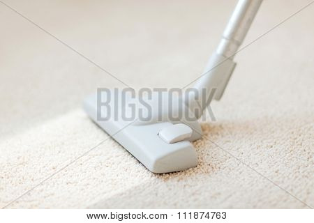 cleaning and home concept - close up of male hoovering carpet