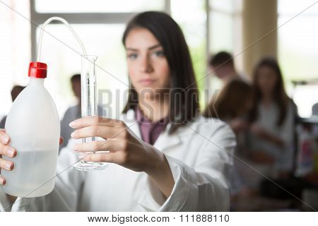 Scientific researcher holding a distilled purified deionised water in plastic bottles with a pump