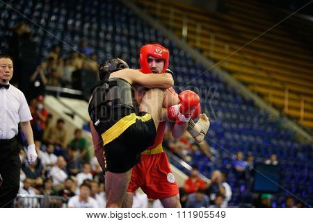 JAKARTA, INDONESIA - NOVEMBER 18, 2015: Ali Abdulkhalikov of Russia (red) fights Ayman Mohamed of Eygpt (black) in the men's 75kg Sanda semi-final event at the 13th World Wushu Championship 2015.