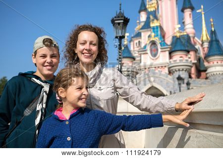 FRANCE, PARIS - 10 SEP, 2014: Young woman with her children (with model releases) are standing near Disneyland castle.