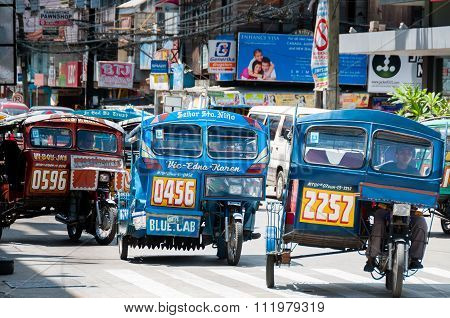 Blue Tricycles of Dumaguete driving on The Road