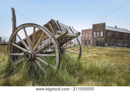 BODIE, CALIFORNIA, USA - August 31, 2017 : Old cart and buildings in Bodie ghost town, California. Bodie is a historic state park from a gold rush era in the Bodie Hills east of the Sierra Nevada