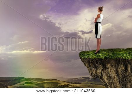 Side view of attractive young woman standing on cliff and looking at beautiful rainbow. Success concept