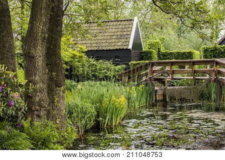 Giethoorn The Netherlands - May 19. 2016: Pond at a monumental house with wooden bridge in the small picturesque town of Giethoorn Overijssel Netherlands.
