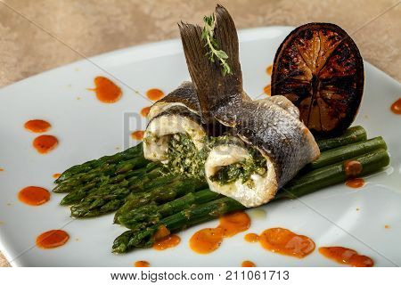 White fish rolls with asparagus and caramelized orange