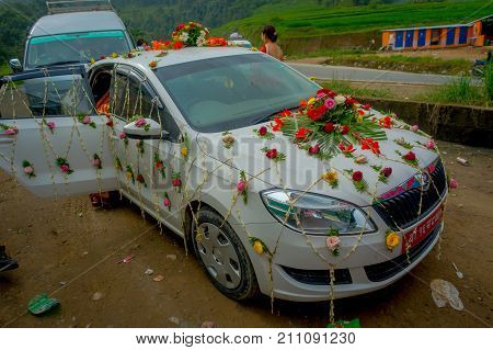 POKHARA, NEPAL OCTOBER 10, 2017: Beautiful car adorned with flowers and villagers celebrating a nepalese wedding in Besisahar, Nepa.